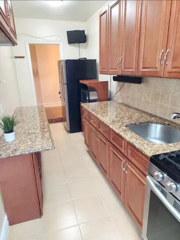 a kitchen with stainless steel appliances granite countertop a stove a sink and a microwave
