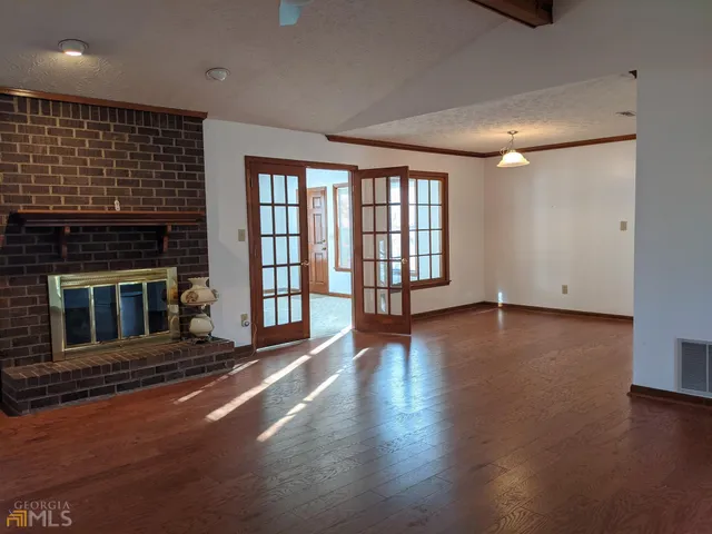 an empty room with wooden floor and a fireplace