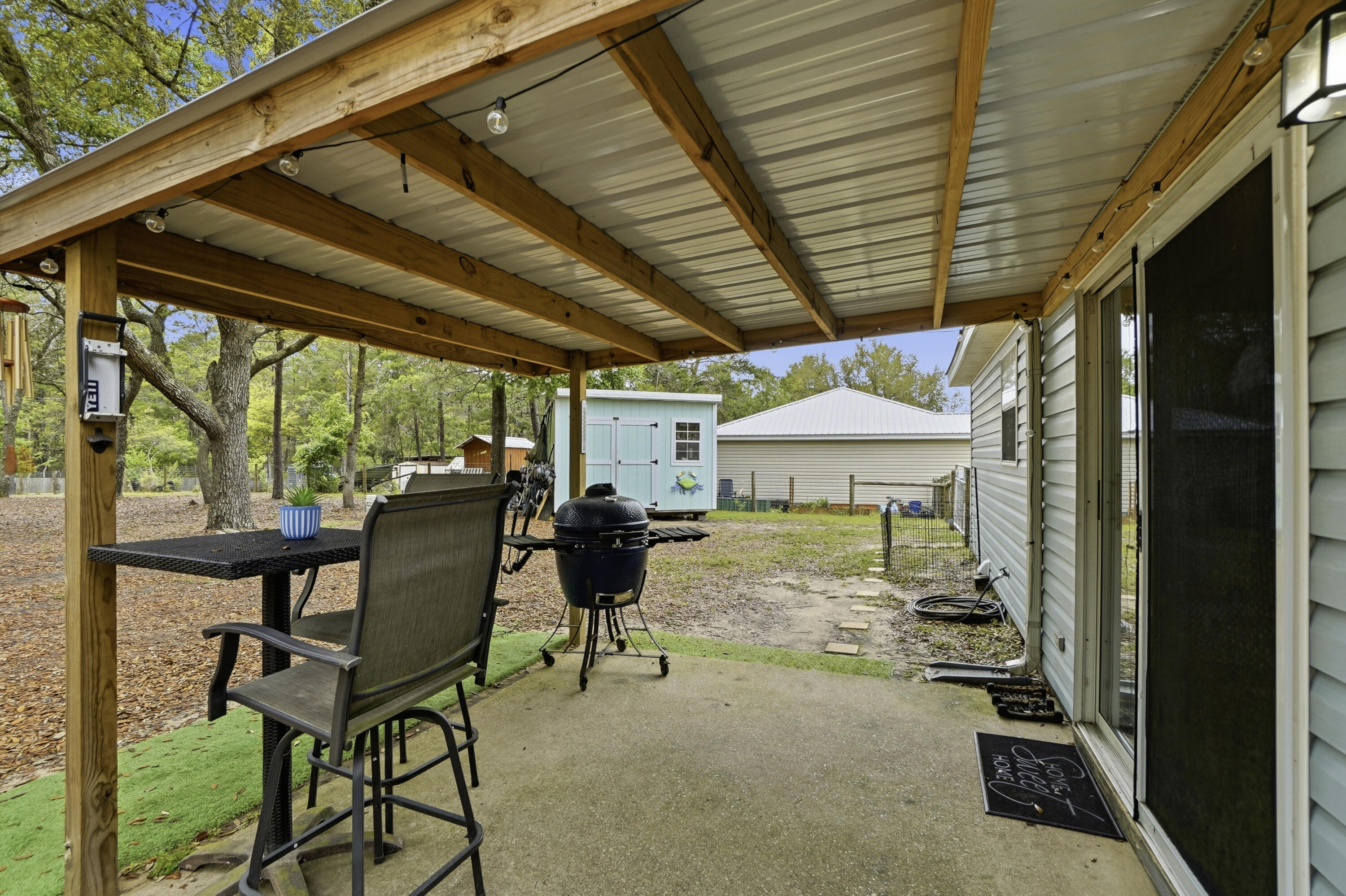 91 Oakridge Way DeFuniak Springs, FL 32433 - Photo 20 of 25 a view of a patio with table and chairs and potted plants