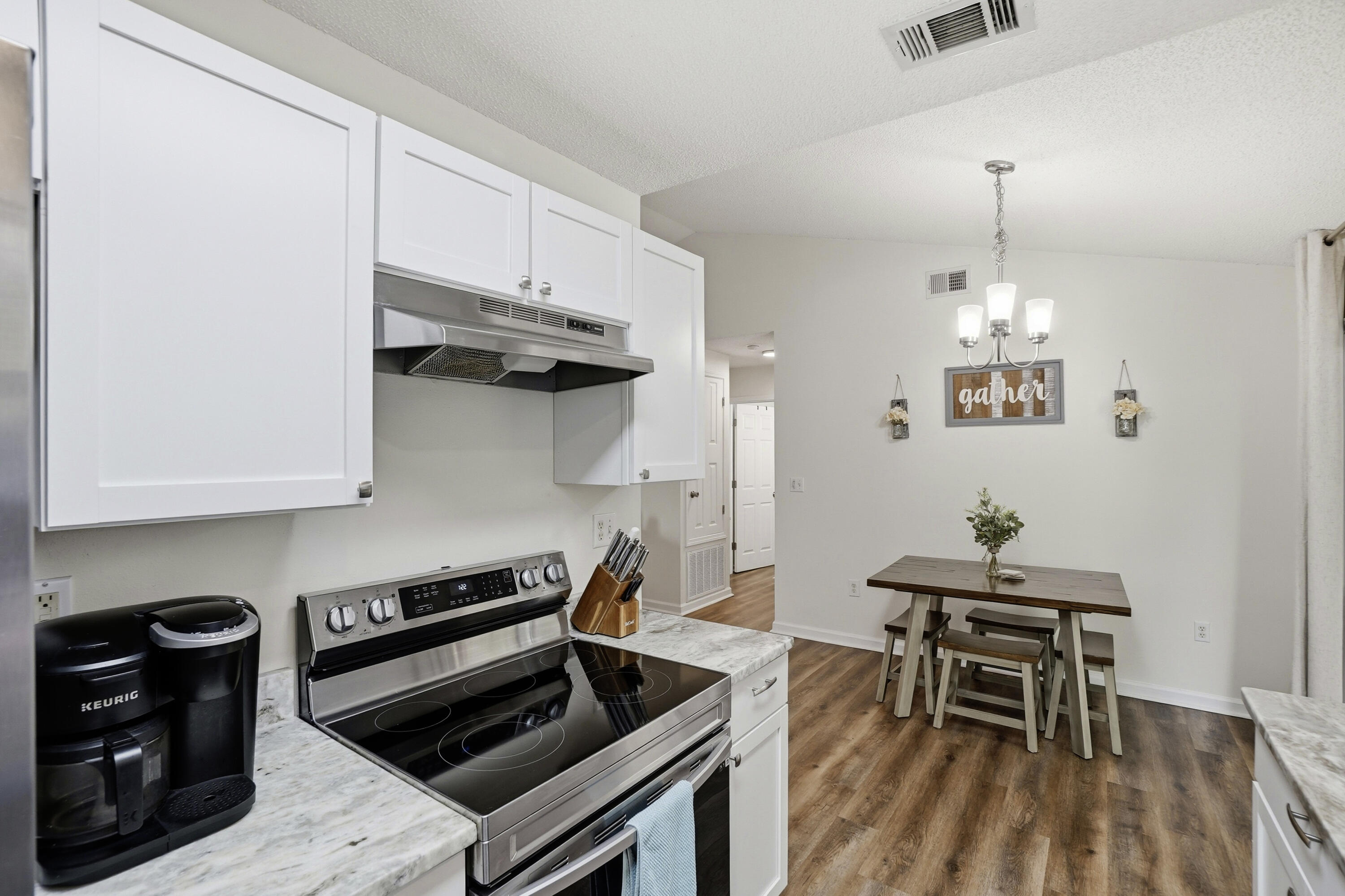 91 Oakridge Way DeFuniak Springs, FL 32433 - Photo 8 of 25 a kitchen with stainless steel appliances a stove a table and chairs in it