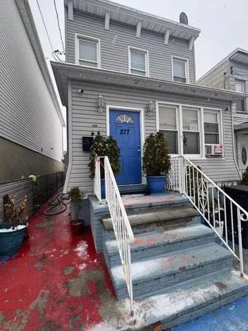 a view of a house with a small yard and wooden floor and fence