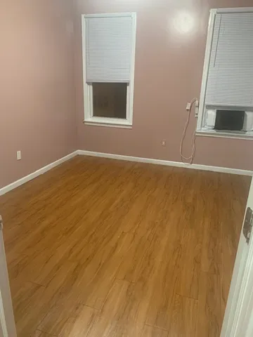 an empty room with a wooden floor and a window