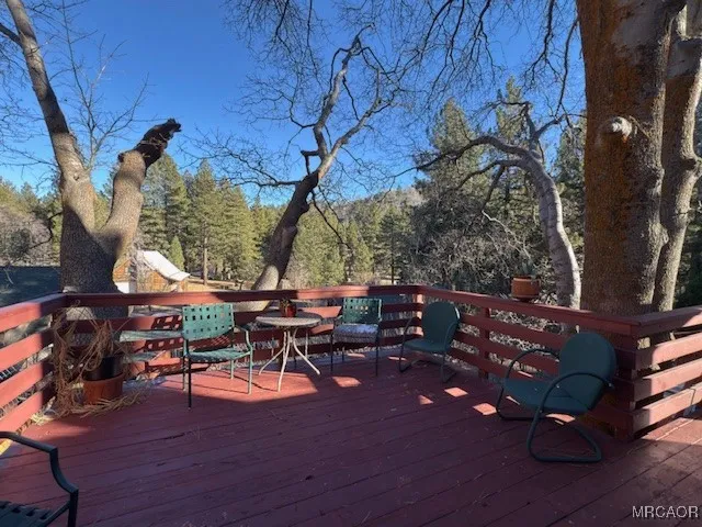 a view of a patio with table and chairs with wooden floor and fence