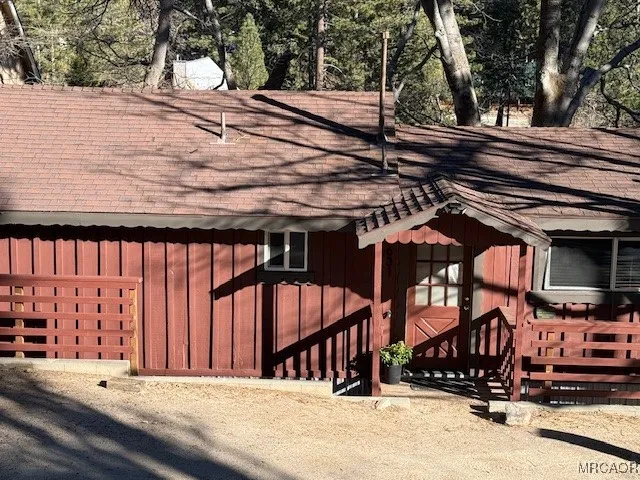 a view of a patio with a table and chairs under an umbrella with wooden fence