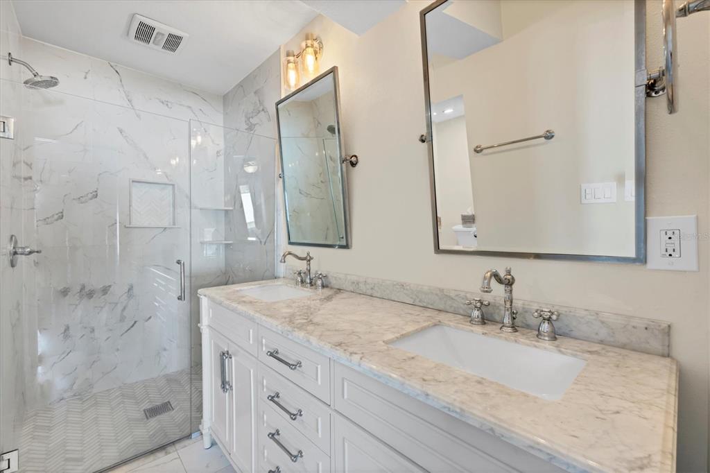 2149 Wason Road Sarasota, FL 34231 - Photo 17 of 32 a bathroom with a granite countertop sink a mirror and a shower