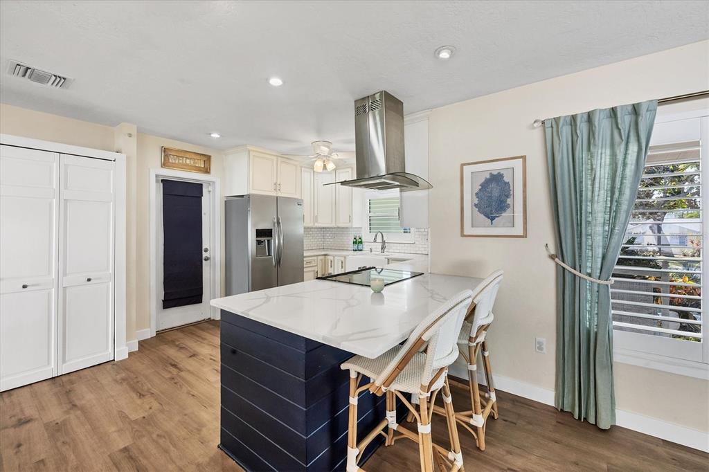 2149 Wason Road Sarasota, FL 34231 - Photo 9 of 32 a kitchen with stainless steel appliances refrigerator wooden floor dining table and chairs