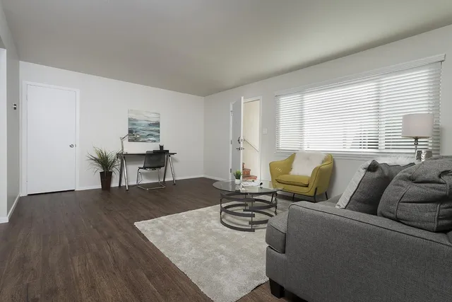 a living room with furniture and a wooden floor