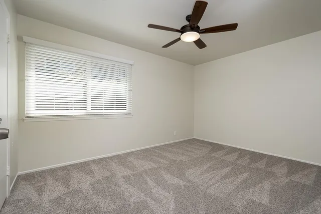 a view of room with a window and a ceiling fan