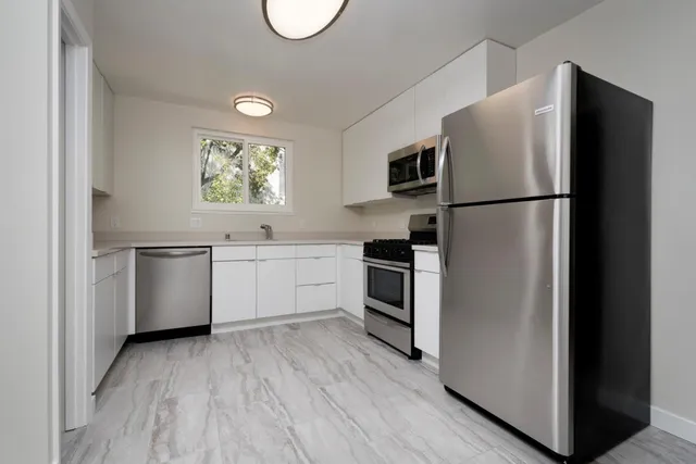 a kitchen with stainless steel appliances a refrigerator sink and cabinets