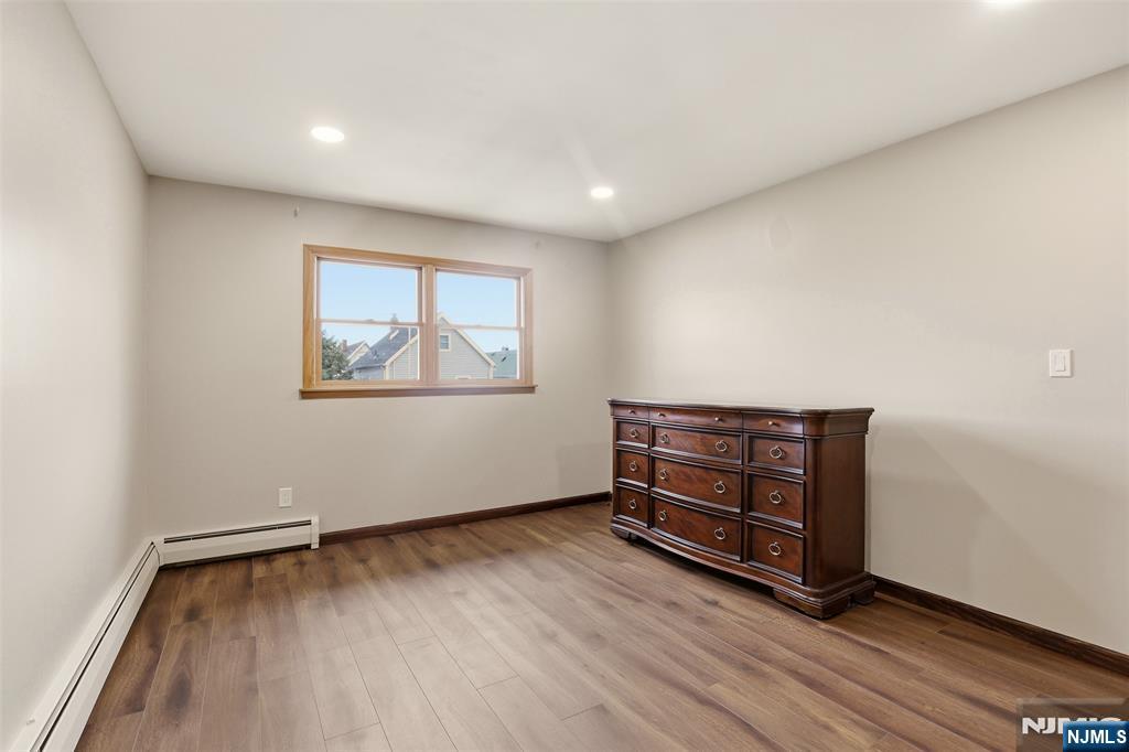 70 Wood Street, Unit 2 Garfield, NJ 07026 - Photo 12 of 23 an empty room with wooden floor and windows