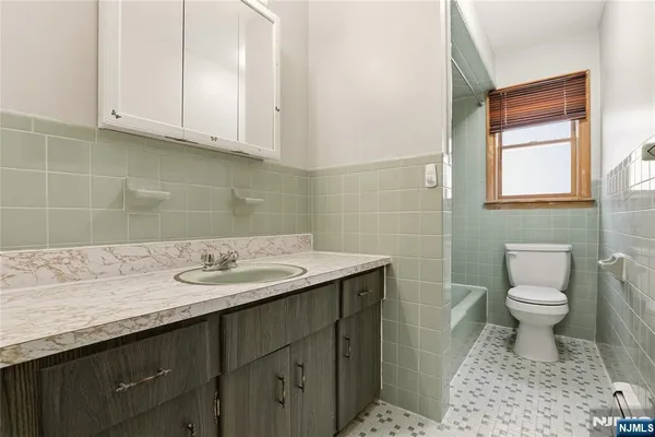 a bathroom with a sink a toilet and a window