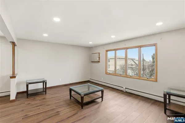 a view of a big room with wooden floor and windows