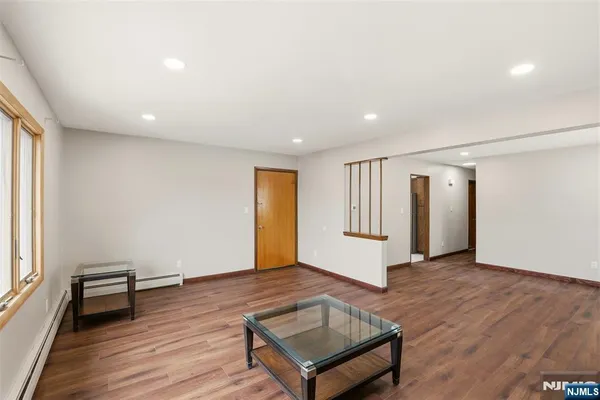 a view of a big room with wooden floor and windows