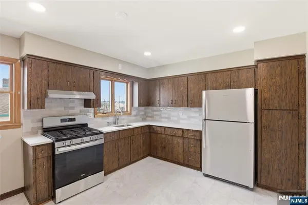 a kitchen with a refrigerator sink and cabinets