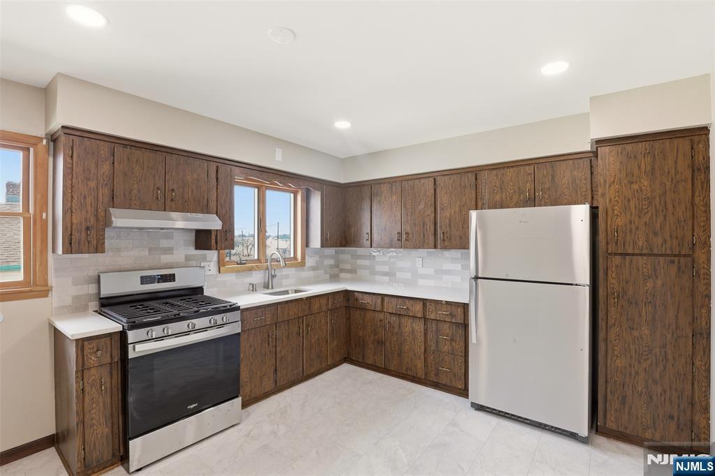 70 Wood Street, Unit 2 Garfield, NJ 07026 - Photo 9 of 23 a kitchen with a refrigerator sink and cabinets