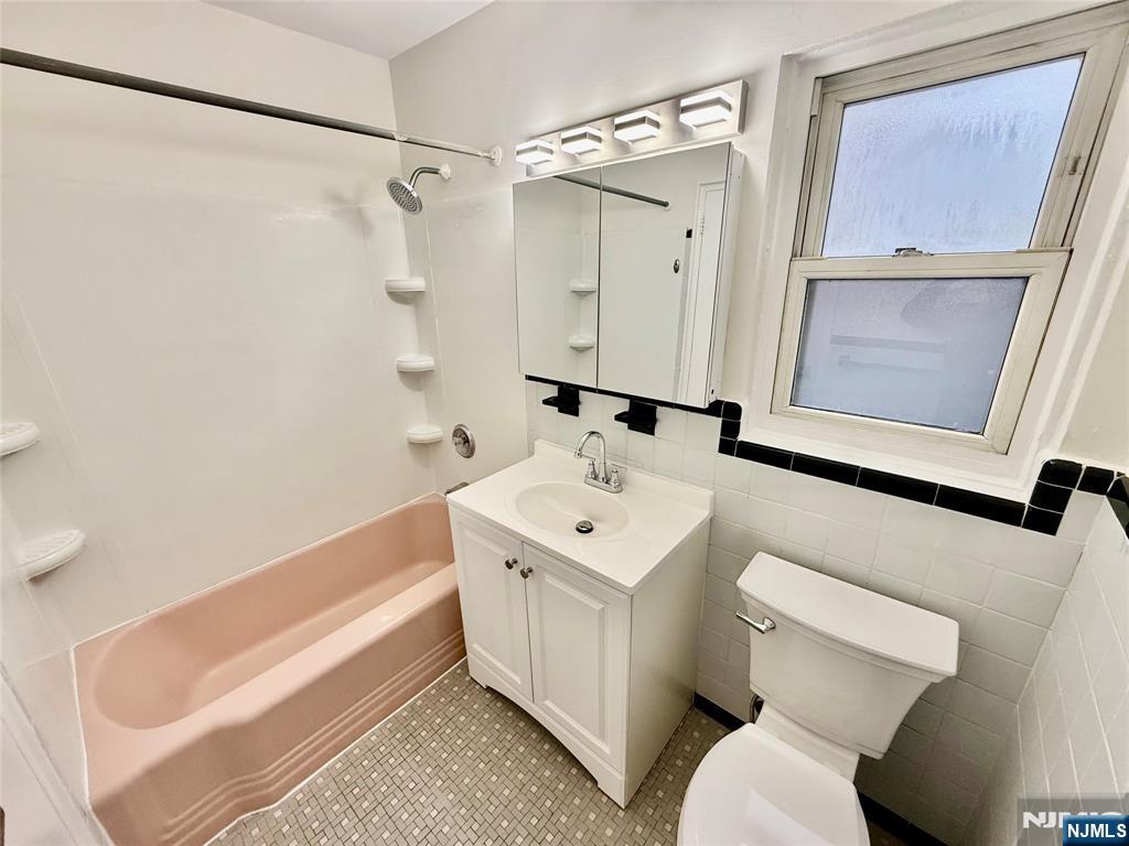 293 Bogert Road, Unit 1A River Edge, NJ 07661 - Photo 10 of 14 a bathroom with a sink a toilet and a mirror