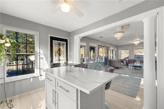 a living room with furniture a flat screen tv and kitchen view