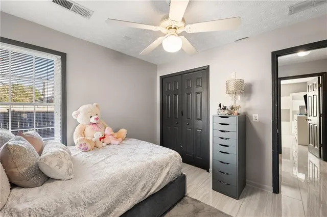 a bedroom with a bed and a flat tv screen on dresser
