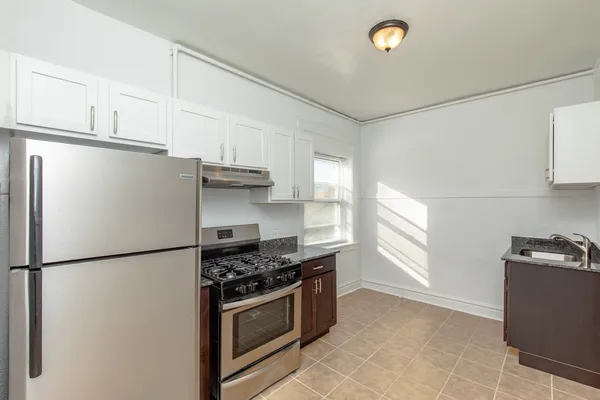 a kitchen with stainless steel appliances granite countertop a refrigerator sink and stove