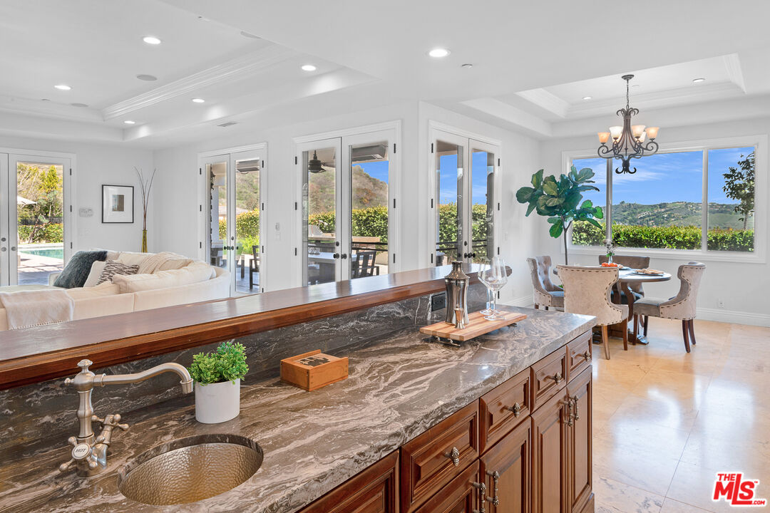 23575 Parksouth Street Calabasas, CA 91302 - Photo 14 of 75 a kitchen with granite countertop a sink a counter top space and living room view
