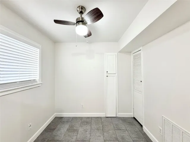 a view of room with a ceiling fan and window