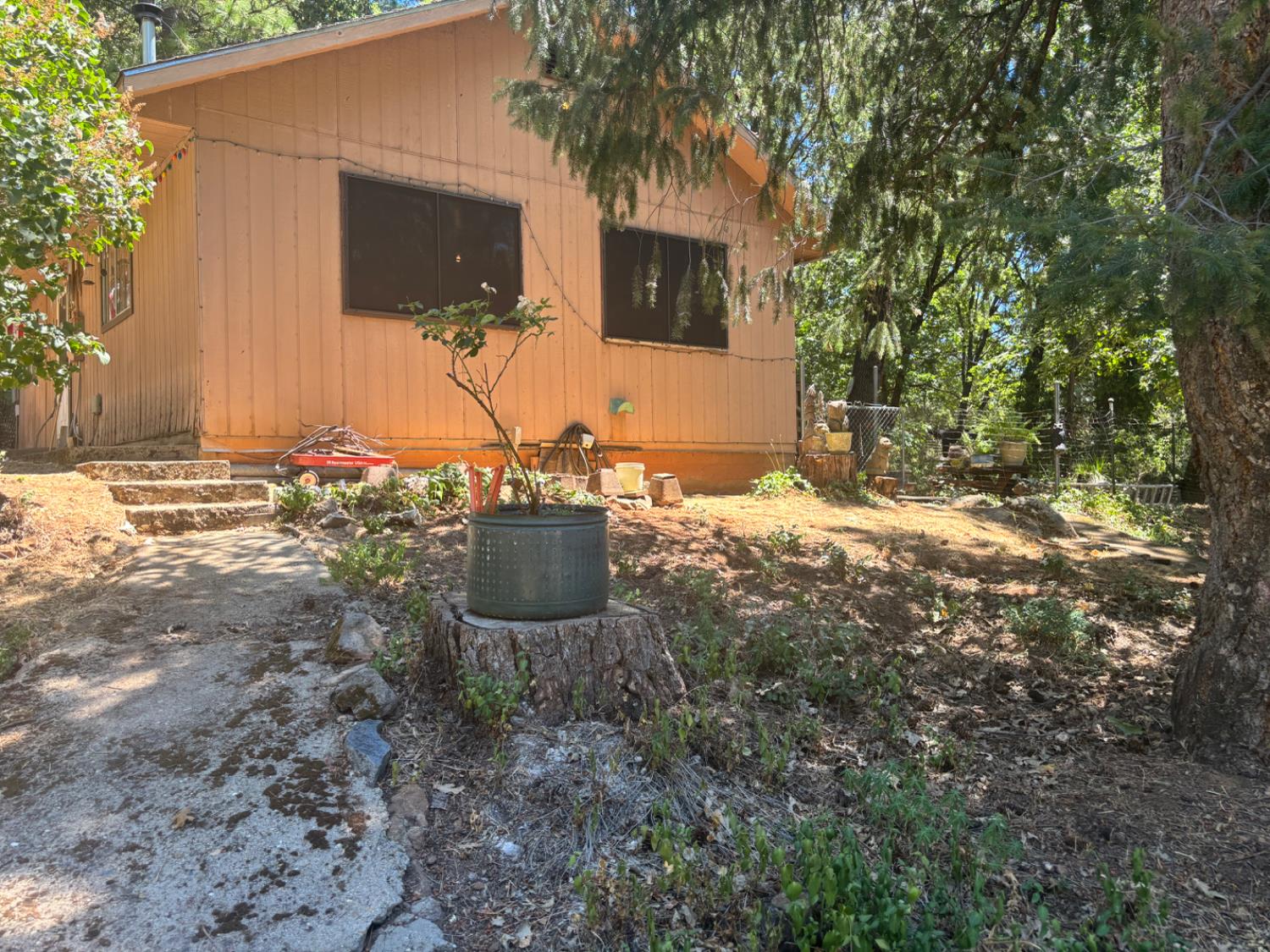 15574 Hinton Road Pioneer, CA 95666 - Photo 21 of 44 a view of a backyard with table and chairs and potted plants