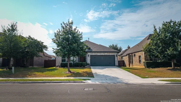 a view of a house with a big yard and large trees