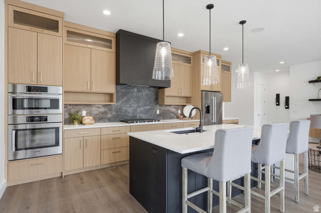 653 East Vandalay Lane Draper, UT 84020 - Photo 22 of 61 Modern kitchen featuring light wood-finish cabinetry and a large center island