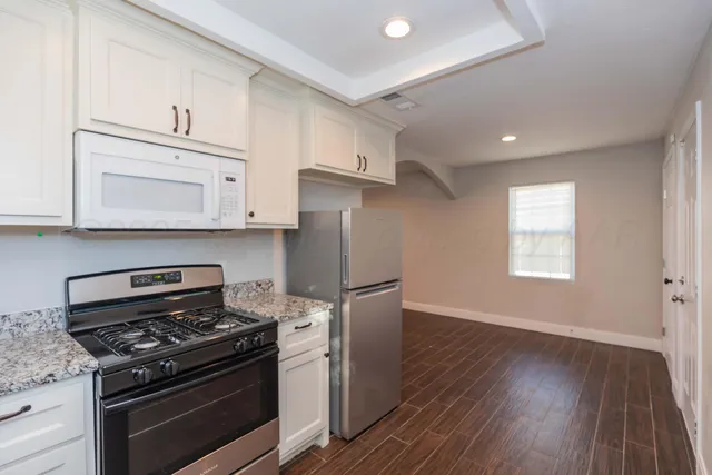 a kitchen with granite countertop a stove and a sink