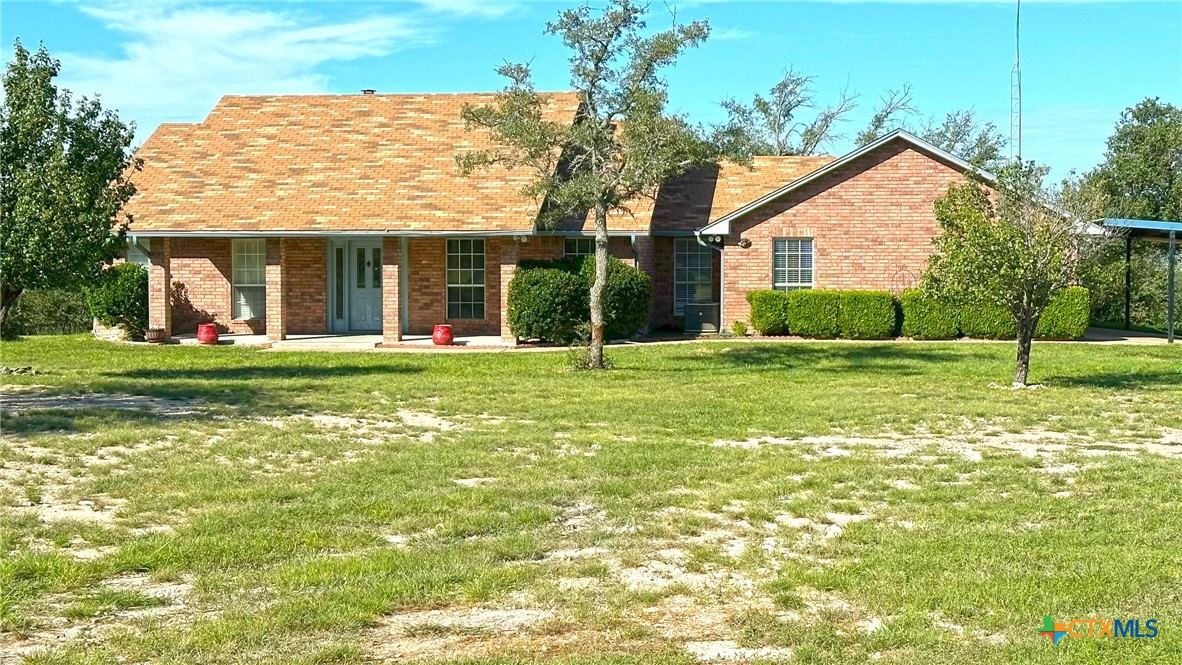 a front view of a house with a yard and trees