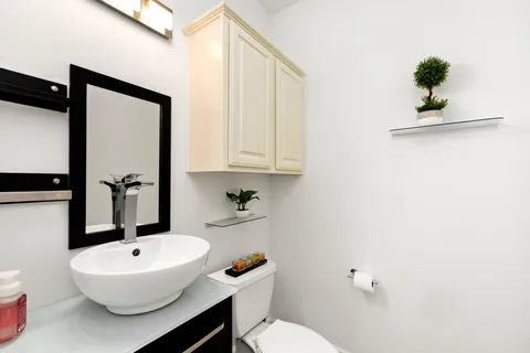 a bathroom with a sink a toilet and a mirror