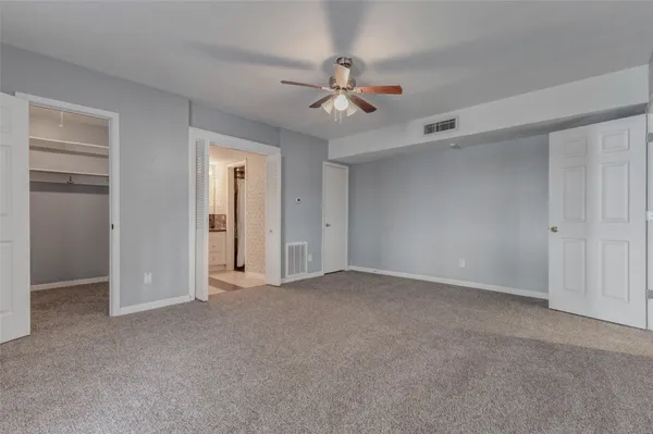 a view of an empty room with a ceiling fan