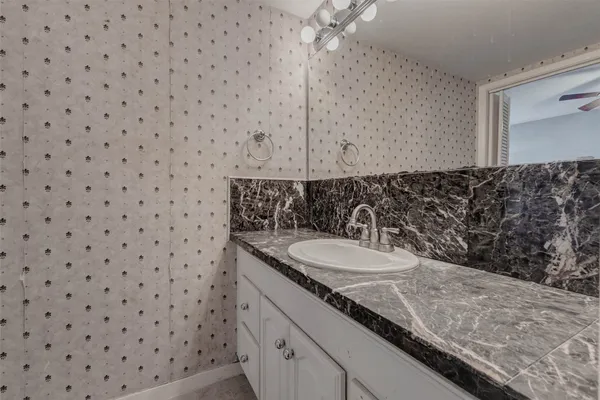 a bathroom with a granite countertop sink a toilet and a mirror
