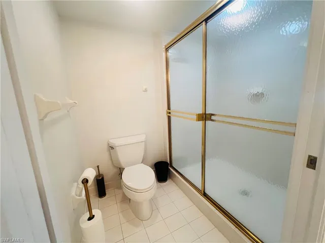 a white toilet sitting next to a shower