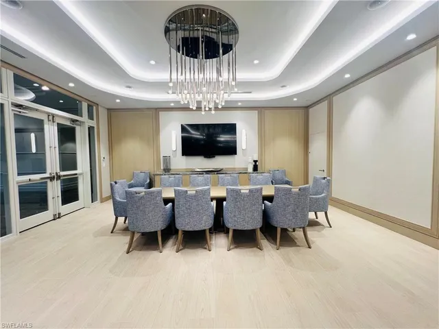 a view of a dining room with furniture a chandelier and window