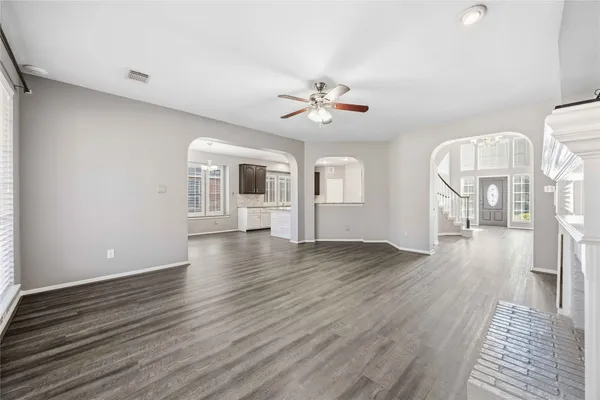 a view of a livingroom with wooden floor and a ceiling fan
