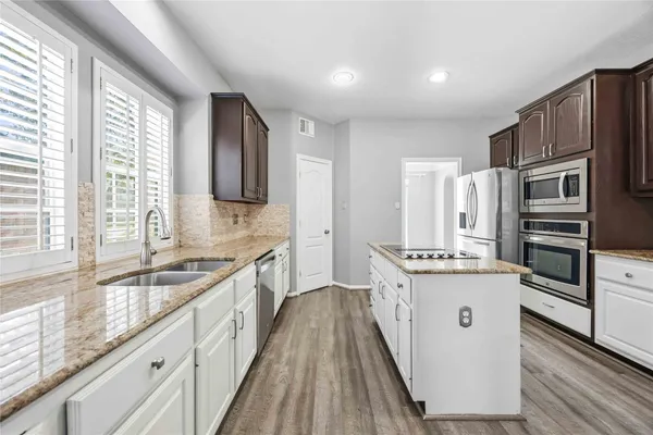 a kitchen with stainless steel appliances granite countertop a stove a sink and a refrigerator