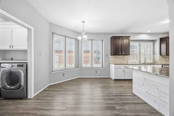 a large kitchen with cabinets wooden floor and stainless steel appliances