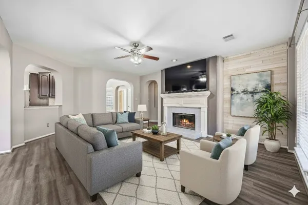 a living room with furniture a flat screen tv and a fireplace