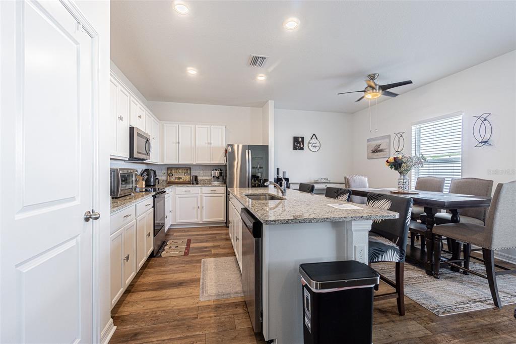 5265 Cricket Hill Road Brooksville, FL 34602 - Photo 13 of 30 a kitchen with cabinets and chairs