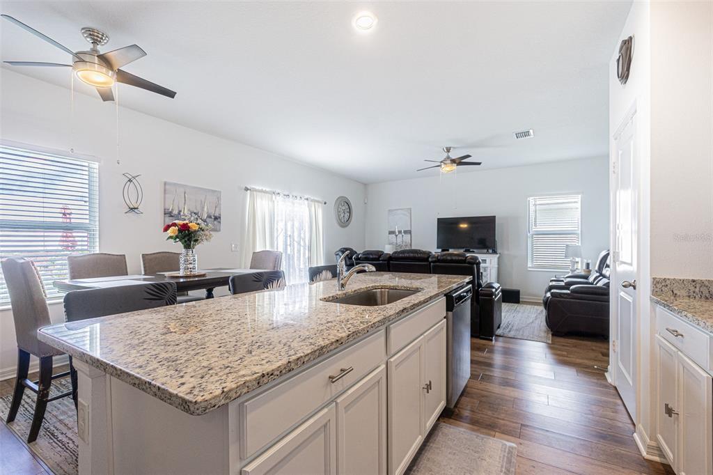 5265 Cricket Hill Road Brooksville, FL 34602 - Photo 16 of 30 a kitchen with stainless steel appliances granite countertop a sink dishwasher stove and refrigerator with wooden floor