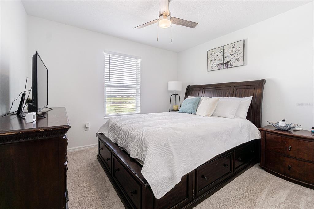 5265 Cricket Hill Road Brooksville, FL 34602 - Photo 23 of 30 a spacious bedroom with a bed and a flat screen tv