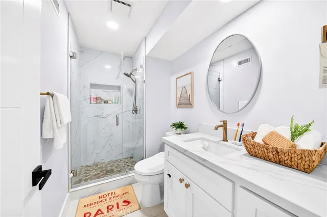 a bathroom with a granite countertop sink mirror vanity and toilet