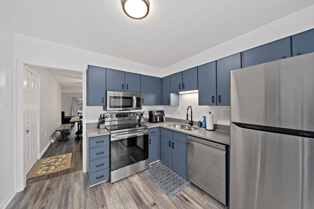 22 Union Square, Unit 22 Randolph, MA 02368 - Photo 9 of 28 a kitchen with a refrigerator a stove top oven a sink and cabinets