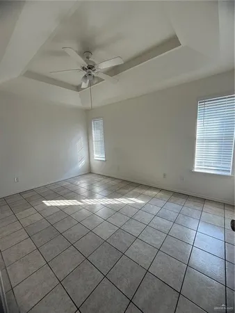 an empty room with windows and ceiling fan