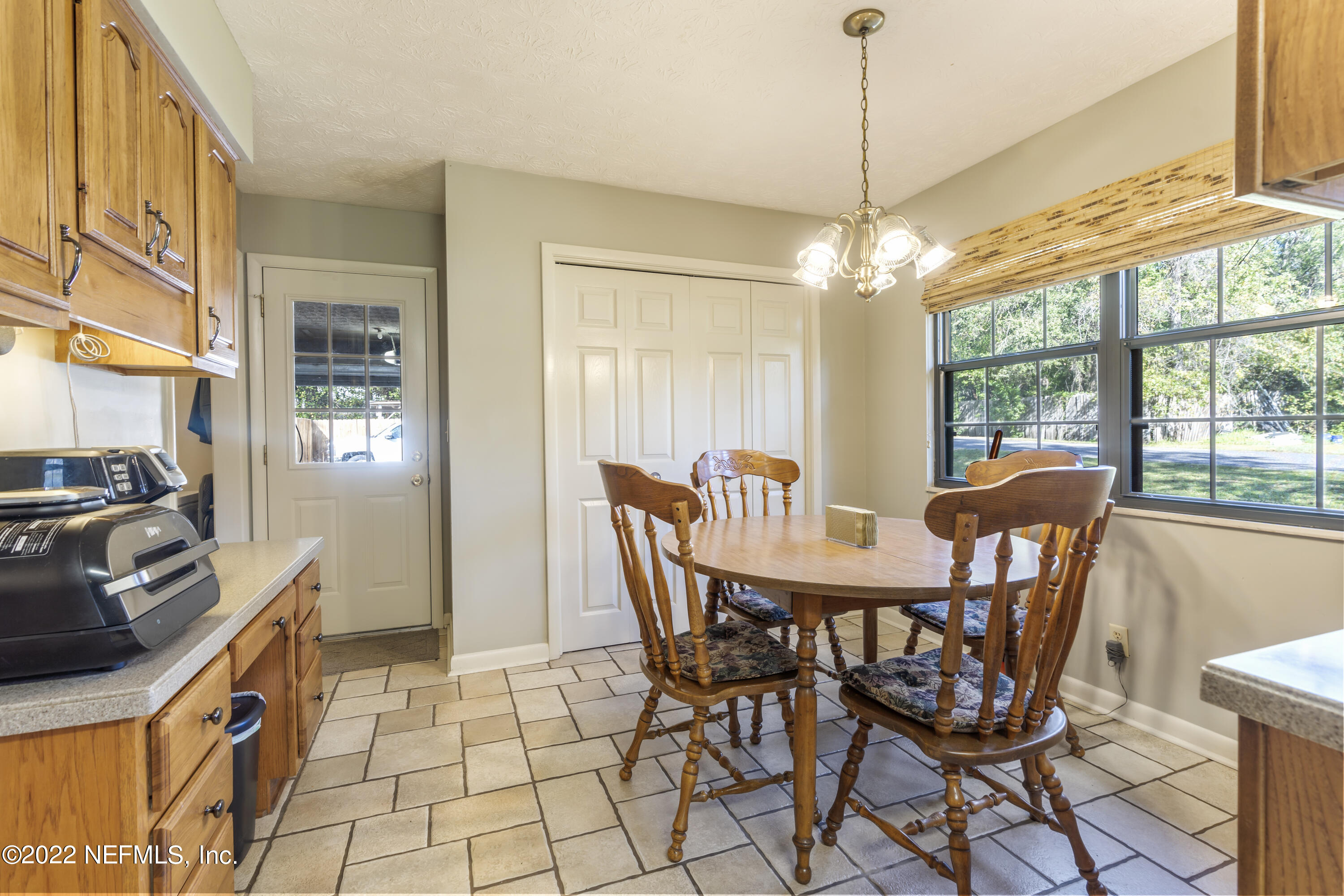4208 Cedar Road Orange Park, FL 32065 - Photo 13 of 37 a dining room with furniture a chandelier and window