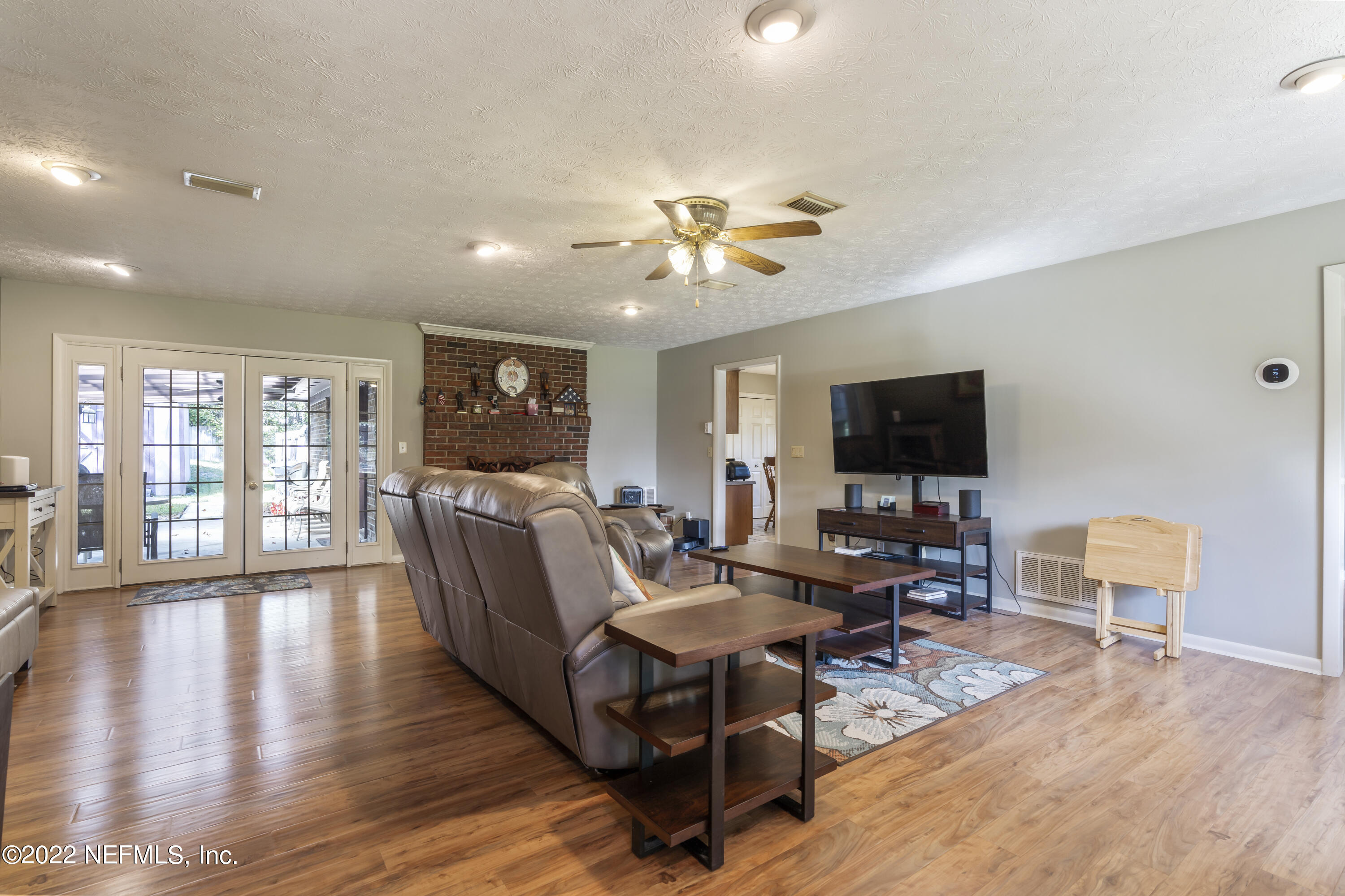 4208 Cedar Road Orange Park, FL 32065 - Photo 5 of 37 a living room with furniture a flat screen tv and a floor to ceiling window