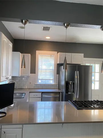 a kitchen with stainless steel appliances granite countertop a sink and a refrigerator