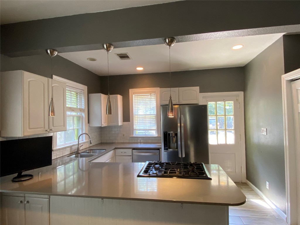 3804 Duval Street Austin, TX 78751 - Photo 13 of 21 a kitchen with stainless steel appliances granite countertop a refrigerator a stove and white cabinets