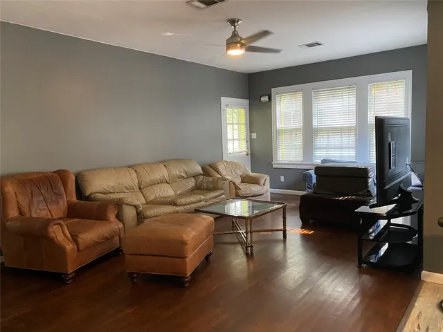 a living room with furniture and a wooden floor